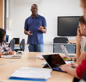 Male Teacher Teaching Children In Class