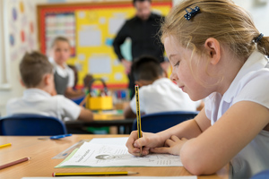 School Girl Writing On Piece Of Paper