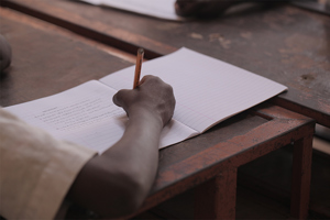 Boy Writing On Piece Paper